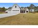 Beautiful white farmhouse-style home with a three-car garage and a large, sloping front lawn and mature landscaping at 4025 Bullock Bridge Rd, Loganville, GA 30052
