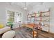 Bright and airy home office with custom shelving, a cozy window seat, wood-look floors, and modern decor at 4025 Bullock Bridge Rd, Loganville, GA 30052