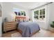 Sunlit bedroom featuring a comfortable bed, wood floors, and stylish decor with nature views at 1770 Beckham Ne Pl # 47, Atlanta, GA 30324