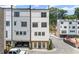 Three-story townhome featuring attached garages, brick accents, and modern architectural details at 1770 Beckham Ne Pl # 47, Atlanta, GA 30324