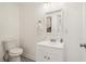 Compact bathroom with a toilet, vanity, mirror, and patterned tile flooring at 679 Forest Ridge Se Dr, Marietta, GA 30067