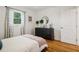 Well-lit bedroom showcasing hardwood floors, modern dresser, and natural light from the window at 679 Forest Ridge Se Dr, Marietta, GA 30067