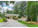 Charming single-story home with a light-colored brick exterior and a long driveway leading to a covered carport at 679 Forest Ridge Se Dr, Marietta, GA 30067