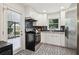 Modern kitchen with stainless steel refrigerator, sleek black appliances, and black and white patterned flooring at 679 Forest Ridge Se Dr, Marietta, GA 30067