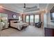 Spacious primary bedroom with a decorative tray ceiling, sitting area, and soft purple walls at 1867 Sterling Chase, Buford, GA 30518