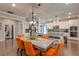 Dining room with a large wooden table and orange chairs leading to a modern kitchen area at 1867 Sterling Chase, Buford, GA 30518