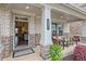 Inviting front porch with brick pillars, seating, and lush landscaping at the home's entrance at 1867 Sterling Chase, Buford, GA 30518