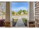 Front porch view with brick columns, landscaping, and neighborhood homes across the street at 1867 Sterling Chase, Buford, GA 30518