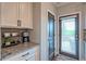 Charming kitchen nook featuring granite countertops, white cabinets, and a convenient coffee station near the back door at 1867 Sterling Chase, Buford, GA 30518