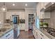 Bright, spacious kitchen with white cabinetry, stainless steel appliances, granite countertops, and hardwood flooring at 1867 Sterling Chase, Buford, GA 30518