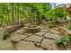 Stone firepit in a backyard with a retaining wall, pavers, and privacy at 3646 Sope Creek Farm Se, Marietta, GA 30067