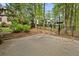 View of fenced basketball court in private backyard featuring a concrete slab, backboard and mature landscaping at 3646 Sope Creek Farm Se, Marietta, GA 30067