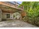 Outdoor living space on a brick patio under a deck with stone columns and mature landscaping at 3646 Sope Creek Farm Se, Marietta, GA 30067