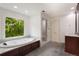 Bathroom featuring a soaking tub, walk-in shower, and serene window view at 3646 Sope Creek Farm Se, Marietta, GA 30067