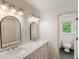 Bathroom featuring double sinks, marble countertops, vanity, and updated lighting at 3646 Sope Creek Farm Se, Marietta, GA 30067