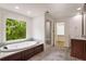 Bathroom featuring a soaking tub, walk-in shower, and serene window view at 3646 Sope Creek Farm Se, Marietta, GA 30067