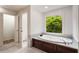 Bathroom featuring a soaking tub with nature views and doorways leading to a closet at 3646 Sope Creek Farm Se, Marietta, GA 30067