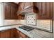 Close-up on kitchen features with granite counters, tile backsplash, stainless gas cooktop, and wood cabinets at 3646 Sope Creek Farm Se, Marietta, GA 30067