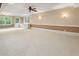 Expansive living room featuring neutral carpet, a ceiling fan, and natural light from large windows at 3646 Sope Creek Farm Se, Marietta, GA 30067