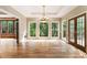 Living room with hardwood floors, chandelier, view into sunroom, and doors to deck at 3646 Sope Creek Farm Se, Marietta, GA 30067
