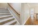 Carpeted staircase with hardwood flooring in the hallway leading to a well-lit area at 3646 Sope Creek Farm Se, Marietta, GA 30067