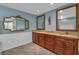Bright bathroom boasts double vanity with granite countertop and decorative mirrors with wood cabinets and wainscotting at 481 Patillo Rd, Stockbridge, GA 30281