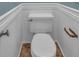 This bathroom has a toilet, wainscoting on the walls, and wood look flooring at 481 Patillo Rd, Stockbridge, GA 30281