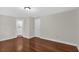 Living room with hardwood floors and white trim, open doorway and closed door at 481 Patillo Rd, Stockbridge, GA 30281