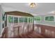 Bright living room with hardwood floors, a wooden accent wall, and sliding doors opening to the outdoor deck area at 481 Patillo Rd, Stockbridge, GA 30281
