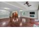 Open-concept living room with hardwood floors, modern lighting, fireplace, and a view into the kitchen at 481 Patillo Rd, Stockbridge, GA 30281