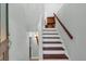 Welcoming entrance foyer with staircase featuring hardwood steps and handrail, offering a glimpse into the kitchen at 481 Patillo Rd, Stockbridge, GA 30281
