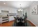 Charming dining area with a round table, elegant chandelier, and natural light from shuttered windows at 432 Ansley Walk Ne Ter, Atlanta, GA 30309