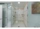 Enclosed shower with beautiful neutral tile surround, built-in shelves, and glass doors at 432 Ansley Walk Ne Ter, Atlanta, GA 30309