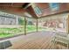 Inviting back porch with wood flooring, skylights, and green backyard views with seating at 524 S Holly Springs Rd, Woodstock, GA 30188