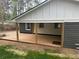 Side view of covered back porch with wood columns and lush greenery at 524 S Holly Springs Rd, Woodstock, GA 30188