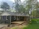 Backyard view of house with a covered porch surrounded by lush greenery at 524 S Holly Springs Rd, Woodstock, GA 30188