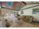 Cozy covered outdoor patio featuring skylights, wood floors, comfortable seating and view to the backyard at 524 S Holly Springs Rd, Woodstock, GA 30188