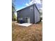 Picture of home's backyard with a stone patio, gray siding, and sliding glass doors at 3049 Morgan Spring Trl, Buford, GA 30519