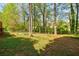 Fenced backyard featuring a lush lawn with mature trees and scattered foliage, offering privacy and shade at 4183 Oak Crest Dr, Tucker, GA 30084