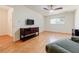 Bedroom featuring a ceiling fan, hardwood floors, and an entertainment console at 4183 Oak Crest Dr, Tucker, GA 30084