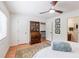 Bright bedroom featuring a ceiling fan, vintage desk, and light-colored hardwood floors at 4183 Oak Crest Dr, Tucker, GA 30084