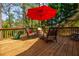 Relaxing deck with a red umbrella, comfortable seating, and a view of the greenery at 4183 Oak Crest Dr, Tucker, GA 30084