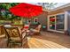 Outdoor wooden deck with seating and a vibrant red patio umbrella at 4183 Oak Crest Dr, Tucker, GA 30084