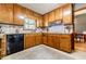 Charming kitchen with wood cabinets, tile backsplash, stainless vent hood, and black dishwasher at 4183 Oak Crest Dr, Tucker, GA 30084