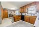 A well-lit kitchen featuring granite countertops, wooden cabinets, and stainless steel appliances at 4183 Oak Crest Dr, Tucker, GA 30084