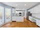 Bright, open kitchen featuring white cabinetry, stainless steel appliances, and hardwood floors at 1075 Pebble Bend Dr, Grayson, GA 30017