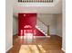 Bright living room featuring hardwood floors, a striking red accent wall and a staircase at 1075 Pebble Bend Dr, Grayson, GA 30017