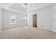 Spacious main bedroom with tray ceiling, ceiling fan, and a door to the main bathroom at 1075 Pebble Bend Dr, Grayson, GA 30017
