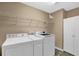 Convenient laundry room equipped with a washer, dryer, and storage shelves at 777 Glen Valley Way, Dacula, GA 30019