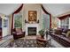 Comfortable living room with a fireplace, large windows dressed with red drapery, and traditional furniture at 777 Glen Valley Way, Dacula, GA 30019